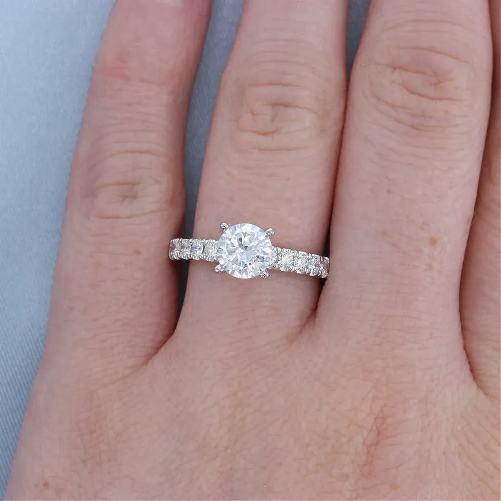 Round diamond engagement ring with a pave band modeled on a hand